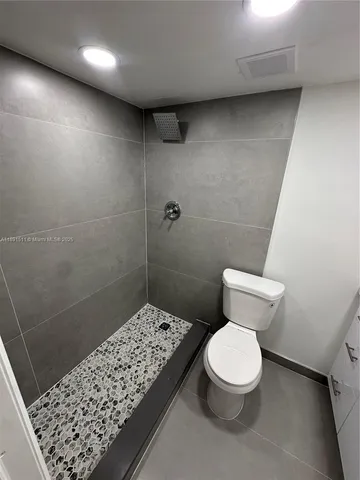 a white toilet sitting next to a bathroom sink