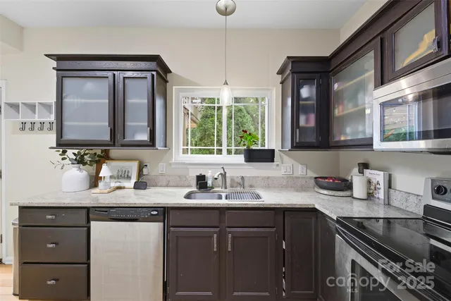 a kitchen with granite countertop a sink stove and cabinets