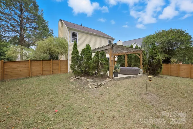 a view of a house with backyard and a tree