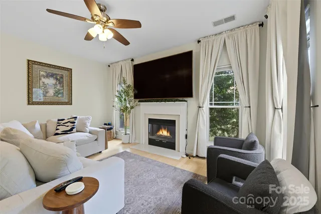 a living room with furniture a fireplace and a flat screen tv