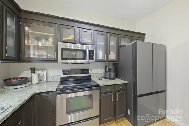a kitchen with stainless steel appliances granite countertop a refrigerator sink and stove