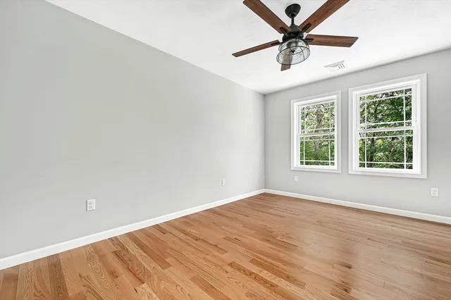 an empty room with a window and a fan
