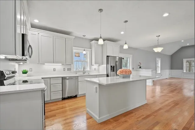 a kitchen with white cabinets appliances and a center island