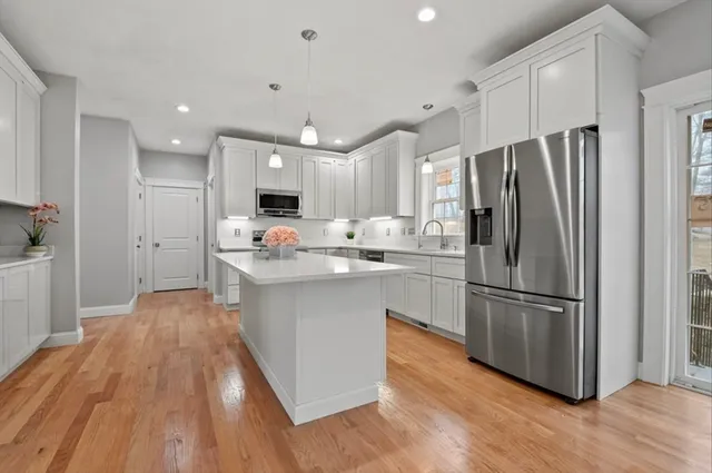 a kitchen with refrigerator cabinets and wooden floor