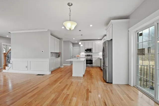 a large kitchen with cabinets wooden floor and stainless steel appliances