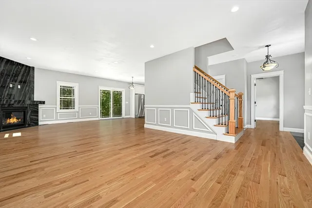 a view of a livingroom with wooden floor and a fireplace