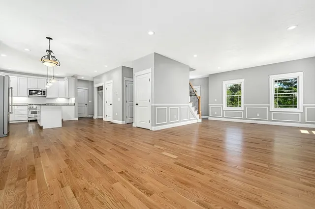 a view of empty room with wooden floor and windows