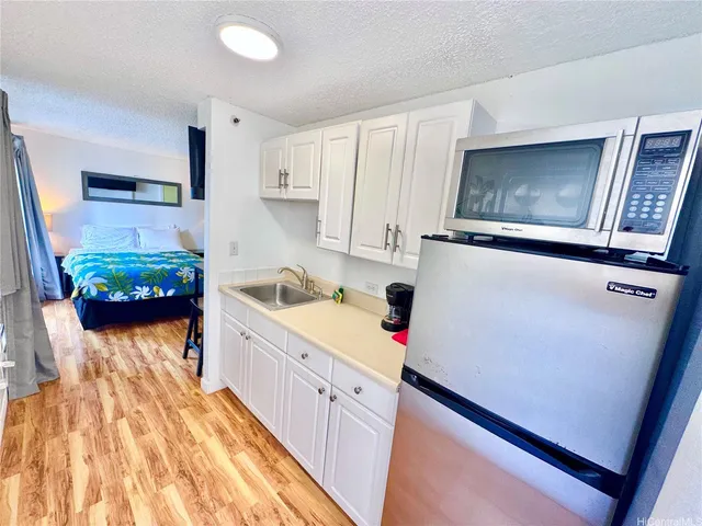 a kitchen with sink refrigerator and stove