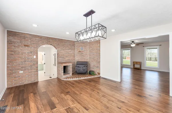 a view of a livingroom with a fireplace wooden floor and staircase