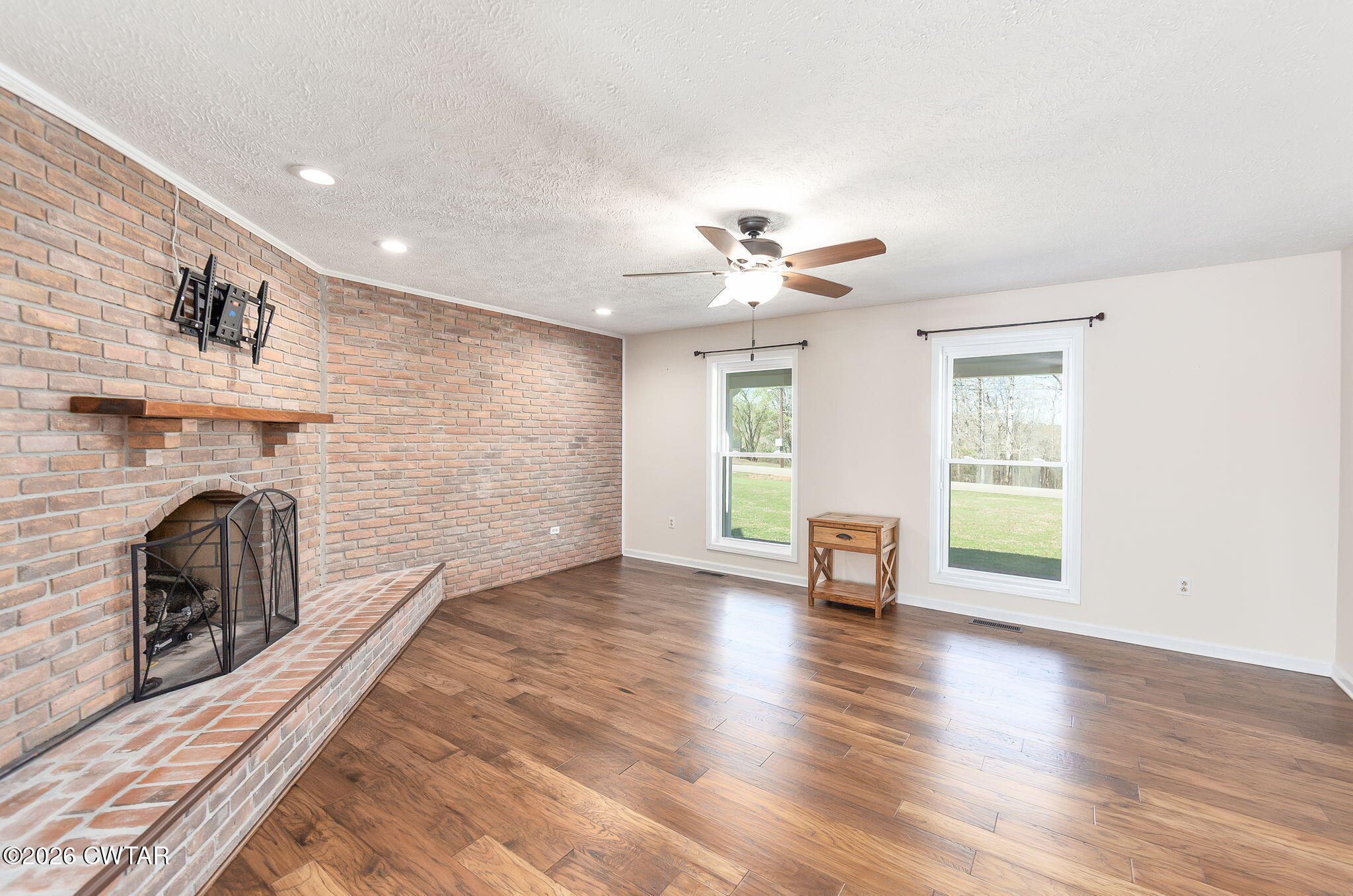 105 Center Hill-Wright Road Reagan, TN 38368 - Photo 5 of 54 an empty room with windows fireplace and wooden floor