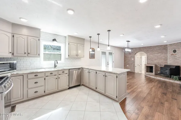 a large white kitchen with cabinets