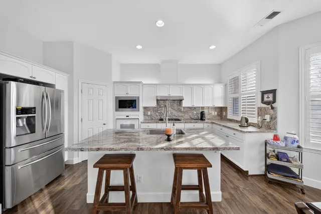 a kitchen with stainless steel appliances a sink a stove and cabinets