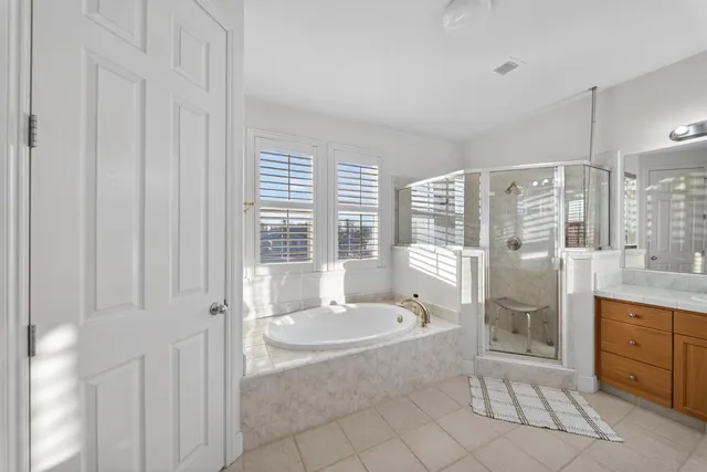 a view of a hallway with wooden floor and a bathroom