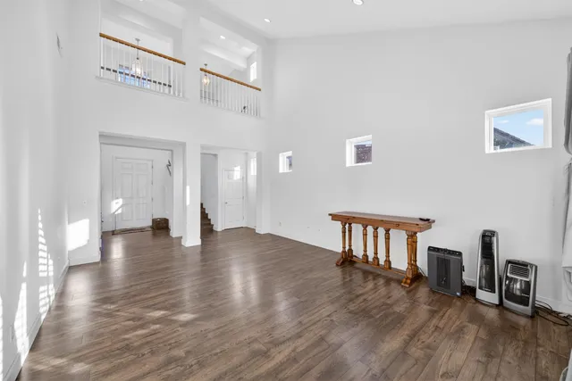 a view of a dining room and livingroom with furniture wooden floor a chandelier