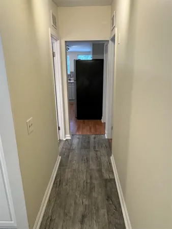 a view of a hallway with wooden floor