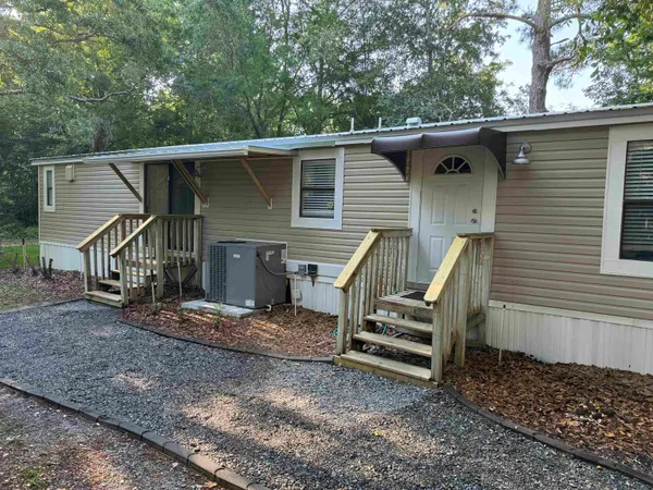 a view of a small house with a floor to ceiling window and a wooden deck