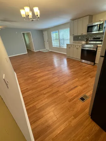 a view of a kitchen with a sink and dishwasher wooden floor