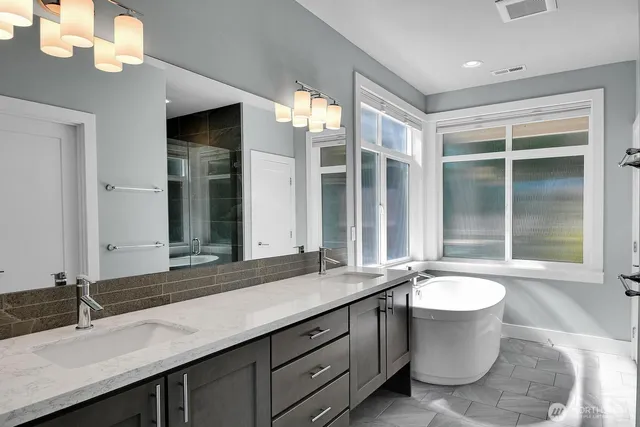 a bathroom with a double vanity sink and a bathtub