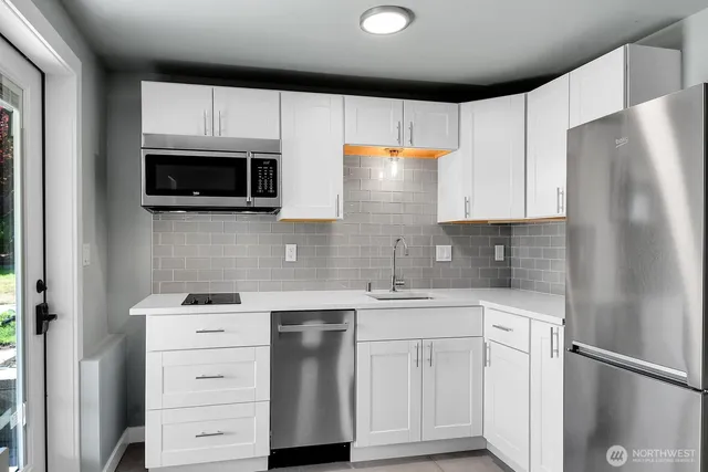 a kitchen with cabinets stainless steel appliances and wooden floor