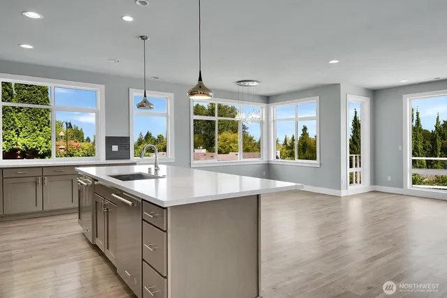 a kitchen with stainless steel appliances granite countertop a sink a stove and a large window