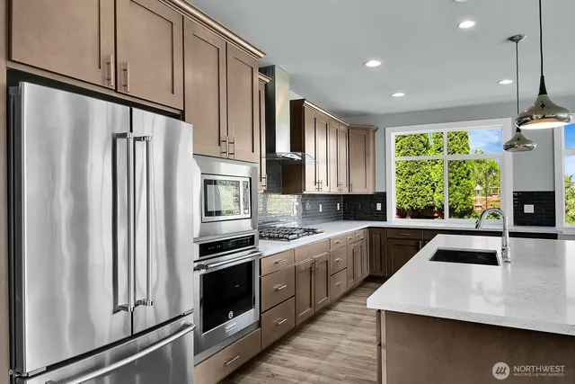 a kitchen with stainless steel appliances a sink cabinets and a window