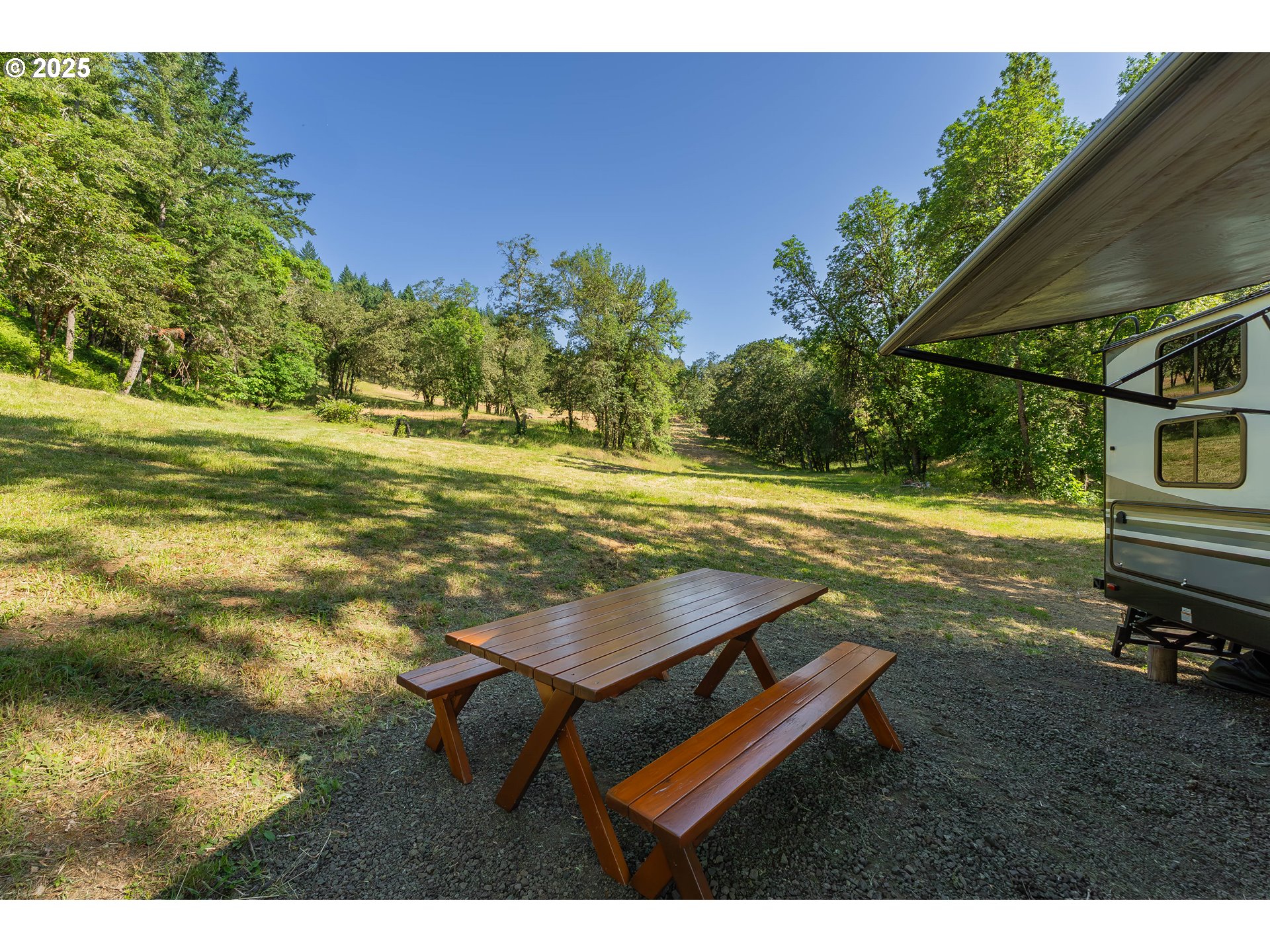 1180 Upper Cleveland Rapids Road Roseburg, OR 97471 - Photo 12 of 42 a view of a backyard with lawn chairs under an umbrella
