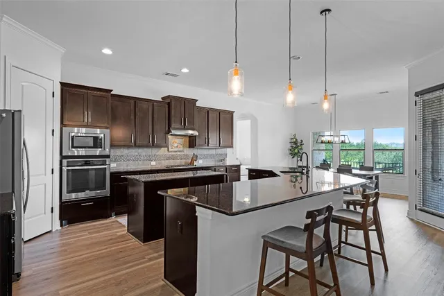 a kitchen with kitchen island a large counter top space appliances and cabinets