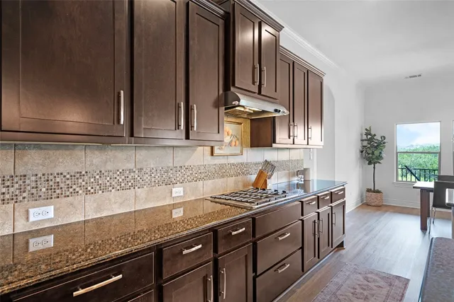 a kitchen with stainless steel appliances granite countertop a sink stove and cabinets