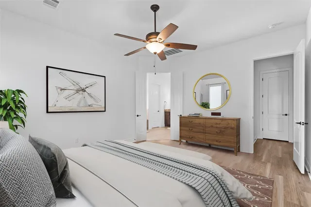 a bedroom with a bed a chandelier and a mirror