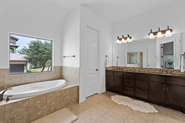 a spacious bathroom with a tub sink and mirror