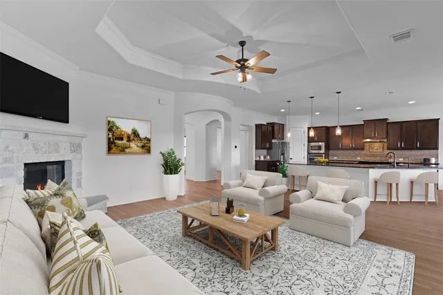 a living room with furniture a flat screen tv and a fireplace