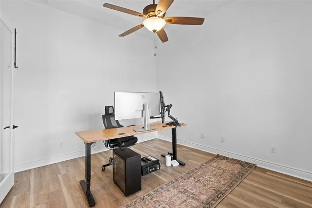 a view of a workspace with furniture and a wooden floor