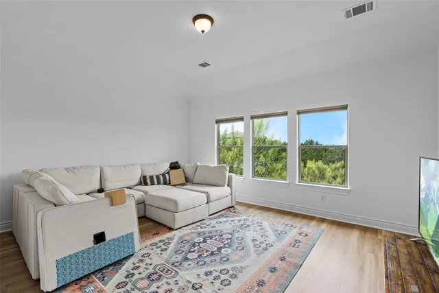 a living room with couches rug and a large window