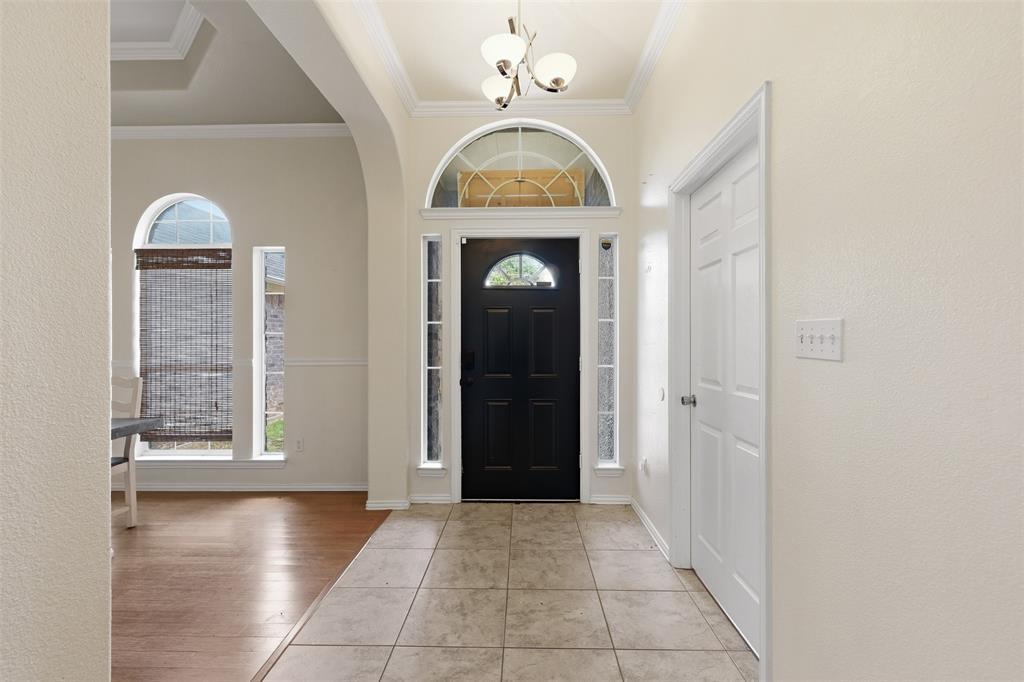 4417 Slayton Road Cleburne, TX 76031 - Photo 12 of 28 Entryway featuring tile flooring, a dark-paneled door with an arched transom, and sidelight windows