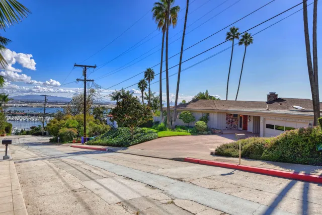 a view of a house with a yard and potted plants
