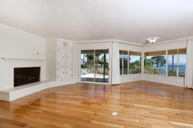 a view of a two room with wooden floor and windows