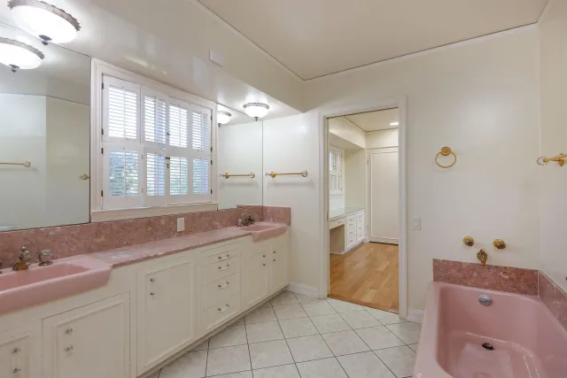 a bathroom with a granite countertop sink a mirror and a bathtub
