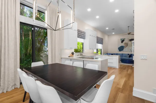 a living room with stainless steel appliances furniture a large window and a table