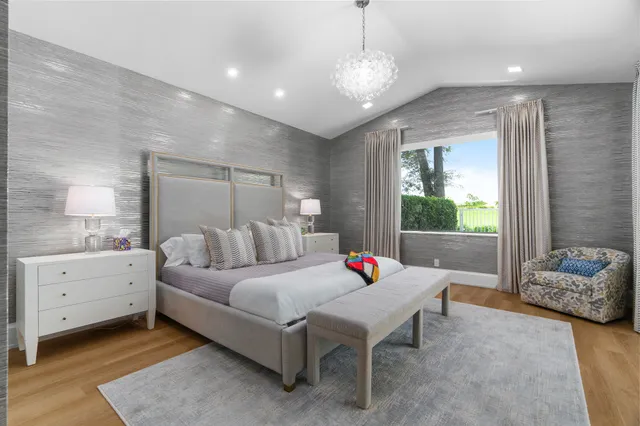 a bedroom with a bed and a large window