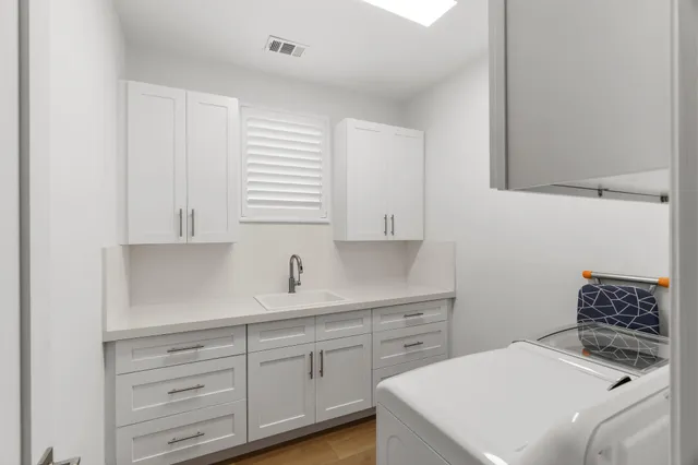 a view of a house with a yard and potted plants