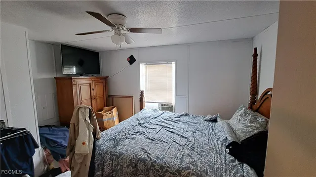 a bedroom with a bed a flat screen tv and a window