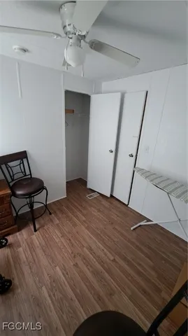 a view of a livingroom with wooden floor and a ceiling fan