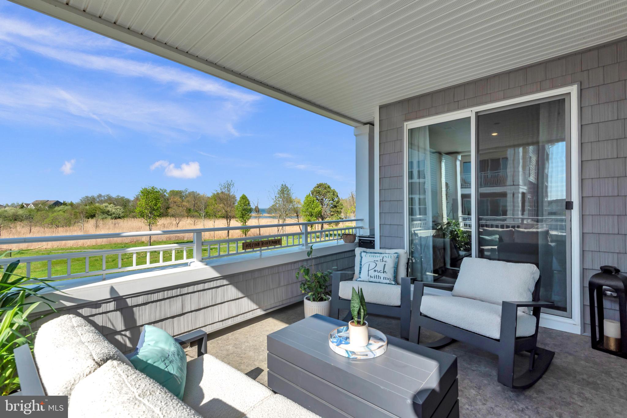 111 Marshgrass Way, Unit 21 Chester, MD 21619 - Photo 37 of 57 a balcony with couple of couches and potted plants