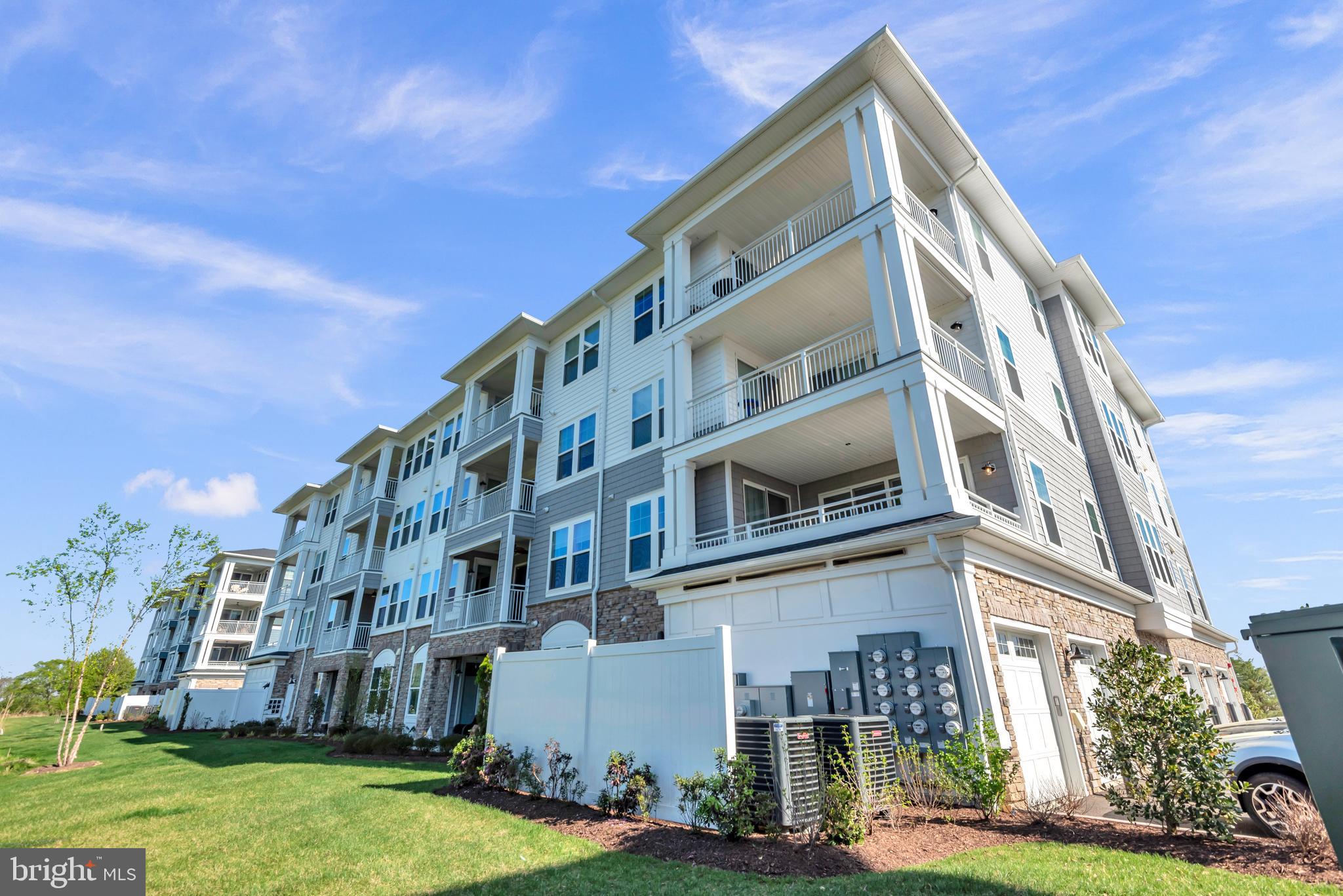 111 Marshgrass Way, Unit 21 Chester, MD 21619 - Photo 40 of 57 a view of a big building with many windows and a yard