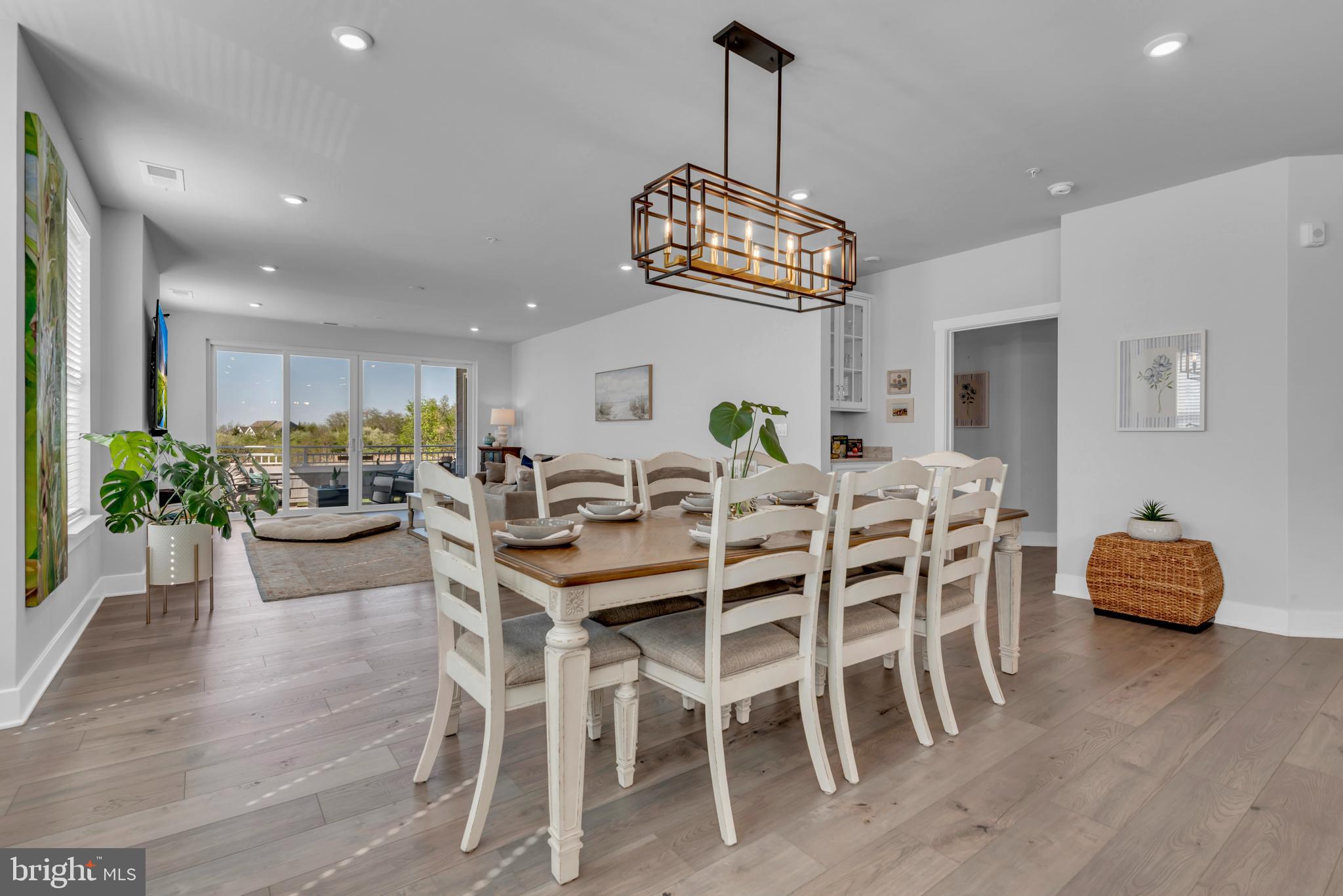 111 Marshgrass Way, Unit 21 Chester, MD 21619 - Photo 6 of 57 a dining room with furniture a chandelier and wooden floor