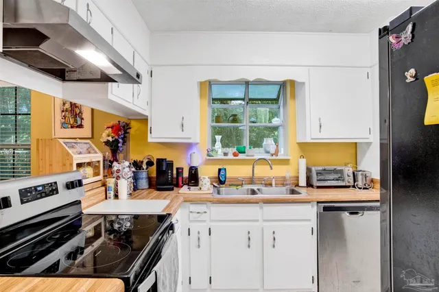 a kitchen with a stove a sink and a refrigerator