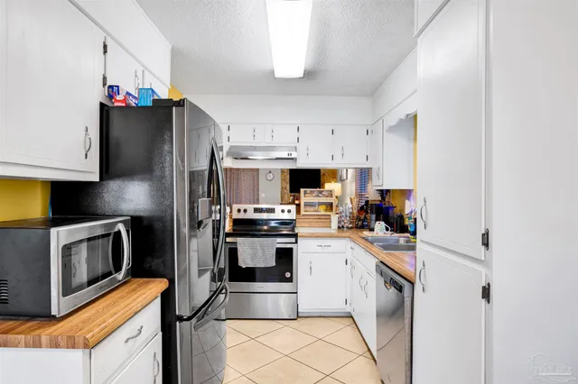a kitchen with a sink stainless steel appliances and white cabinets