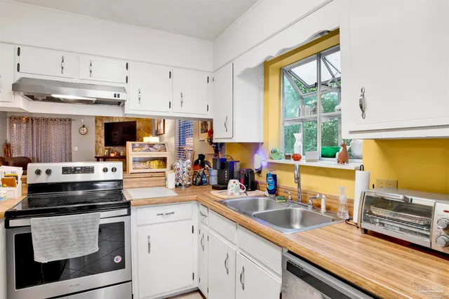 a kitchen with stainless steel appliances a stove sink and cabinets