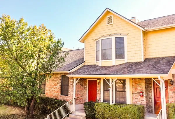 a front view of a house with a tree