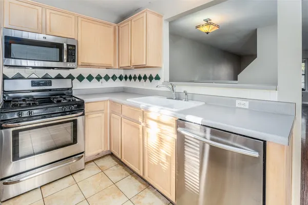 a kitchen with stainless steel appliances granite countertop a sink and a stove